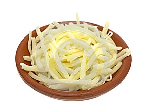 Portion of natural white mild cheddar cheese in bowl