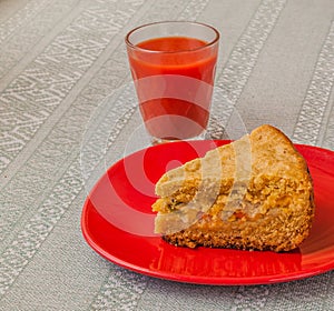 Portion of oat flour cake and glass of tomato juice