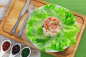 Portion of olivier salad with red caviar on white plate