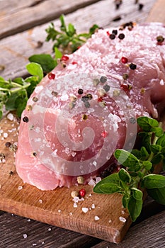 Portion of pork meat with salt crust and few pieces of oregano herb