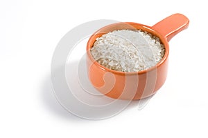 A portion of raw rice in a clay bowl on a white background