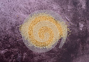 Portion of raw sugar on a maroon background