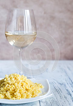 Portion of risotto with glass of white wine