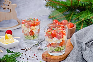 Portion salad with smoked salmon, avocado, egg, cherry tomatoes with cream cheese dressing in a glass.