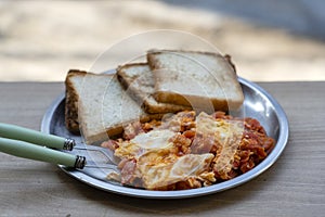 Portion of shakshuka on a plate. Middle eastern traditional dish with fried eggs, tomatoes, bell pepper and vegetables