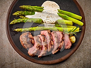 Portion of sliced beef steak and asparagus