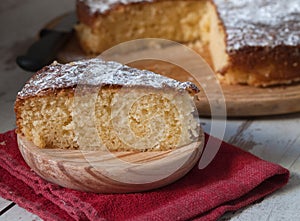 Portion of a sponge cake on a wooden plate