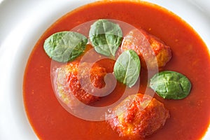 Portion of tomato soup with meatballs