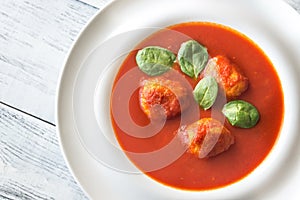 Portion of tomato soup with meatballs