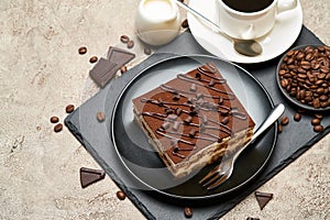 Portion of Traditional Italian Tiramisu dessert and cup of espresso coffee on grey concrete background