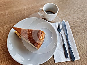 A portion of vanilla tart and coffee in a cafe