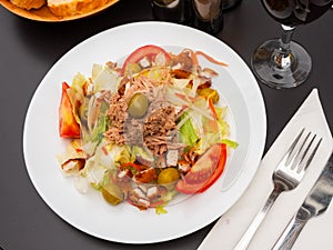 Portion of warm salad made of fresh seasonal vegetables and tender pork meat