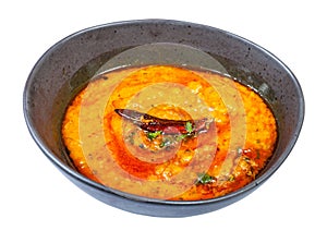 Portion of yellow Dal Tadka in black bowl isolated