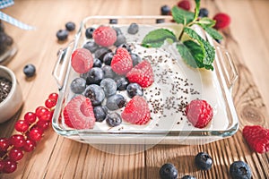 Portion of yogurt with berries serving in glass bowl