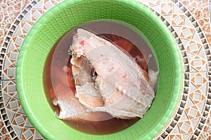 Portioned fish in green bowl