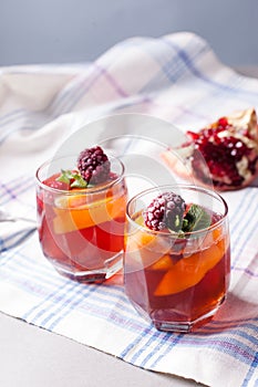 Portioned fruit dessert in glass cups kremankah - jelly with fruit and mint, low-calorie summer snack.