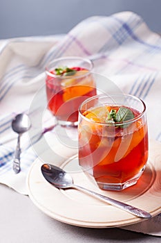 Portioned fruit dessert in glass cups kremankah - jelly with fruit and mint, low-calorie summer snack.