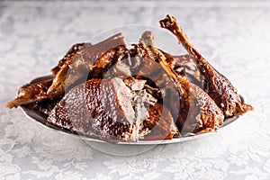 Portioned roast goose on a white plate - Close up