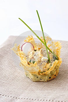 Portioned snack in baked crispy cheese tartlet