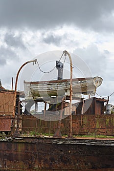 The Portlairge Lifeboat sits in its Davit with the Boat rusting all around it on the beach at St Kieran`s Quay.