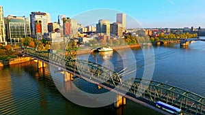 Portland Aerial: Golden Hour, Hawthorne Bridge, speeding boat, and Scenic Bridges & Moda Center in distance in Cityscape