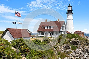Portland lighthouse with American flag by the sea at Fort Williams Park photo