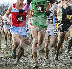 Boys racing cross country in the mud