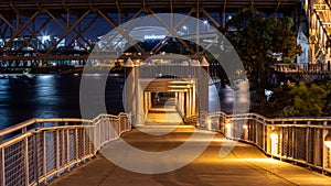 Night photo of Eastbank esplanade walkway under Burnside bridge over Wilamette river. photo