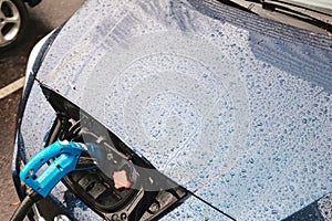 Cool blue car getting charged to be ready to take off