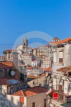 Porto with old ancient buildings, orange roofs and gray walls and blue sky