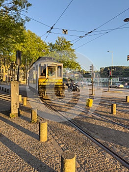 PORTO, PORTUGAL - 5 APRIL 2023: Wooden historical vintage tram moving on Porto street, symbol of city. Old tram passing by in