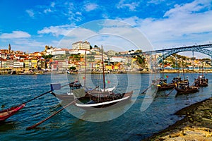 Porto, Portugal, Riberia old town cityscape with Dom Lusi bridge and the Douro River with traditional Rabelo boats