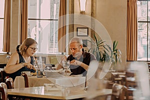 Some visitors having breakfast inside retro style restaurant with wooden furniture