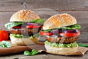 Portobello mushroom meatless burgers against a dark wood background