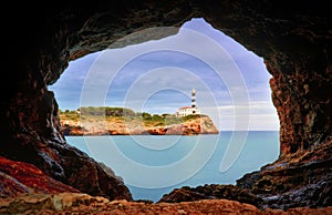 Portocolom lighthouse, stone cave, calm blue sea, mallorca, spain