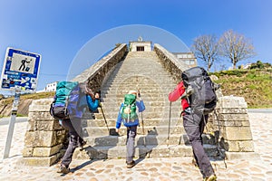 Portomarin, Spain - Two Adults and Child Pilgrims Ascending Stairs at City Entrance to Portomarin, along the Way of St James photo