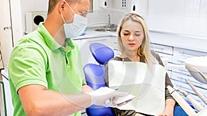 Portrai t of male dentist writing prescription and treatment to his patient