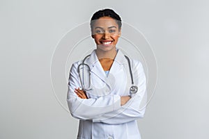 Portraif of black female doctor with stethoscope posing with crossed hands