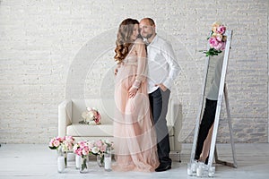 Portraint of pregnant woman and her husband at studio