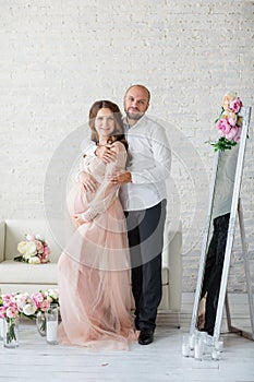 Portraint of pregnant woman and her husband at studio