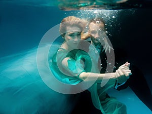 Portrair of young dancing couple underwater