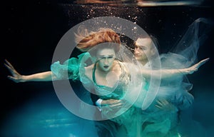 Portrair of young dancing couple underwater