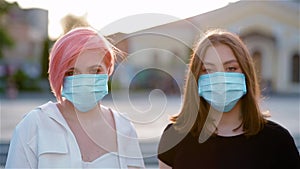 Portrairt of two young ladies taking off medical masks