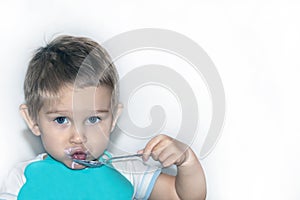 Portrait of a 1-2 year old boy with a spoon in his hand. Toned.