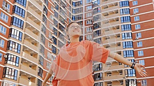 Portrait of a 16-year-old girl after moving to a new neighborhood against the background of high-rise buildings.