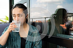 Portrait of a 32 year old Japanese woman drinking a glass of water