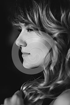 Portrait of a 36 year old woman with curly hair and brown slanting eyes. Soft selective focus. Black and white art photo