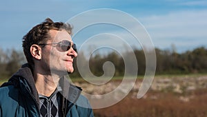 Portrait of a 40 year old white man, looking away, standing in a seaside nature reserve near Blankenberge