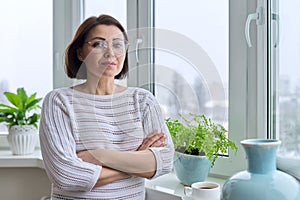 Portrait of 45 years old woman looking at camera with crossed arms