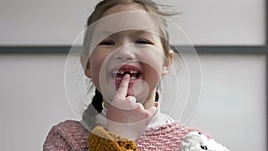 Portrait of a 6-7 year old girl rejoicing at a lost tooth. The concept of changing teeth.
